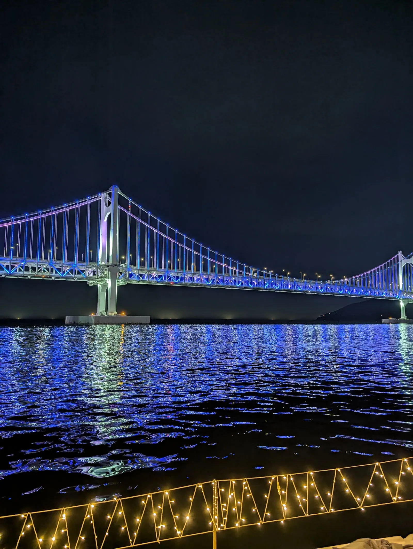 El puente Gwangan iluminado, visto desde el barco