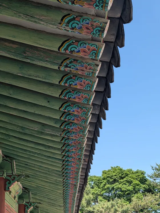 Aleros pintados con dancheong contra el cielo azul
