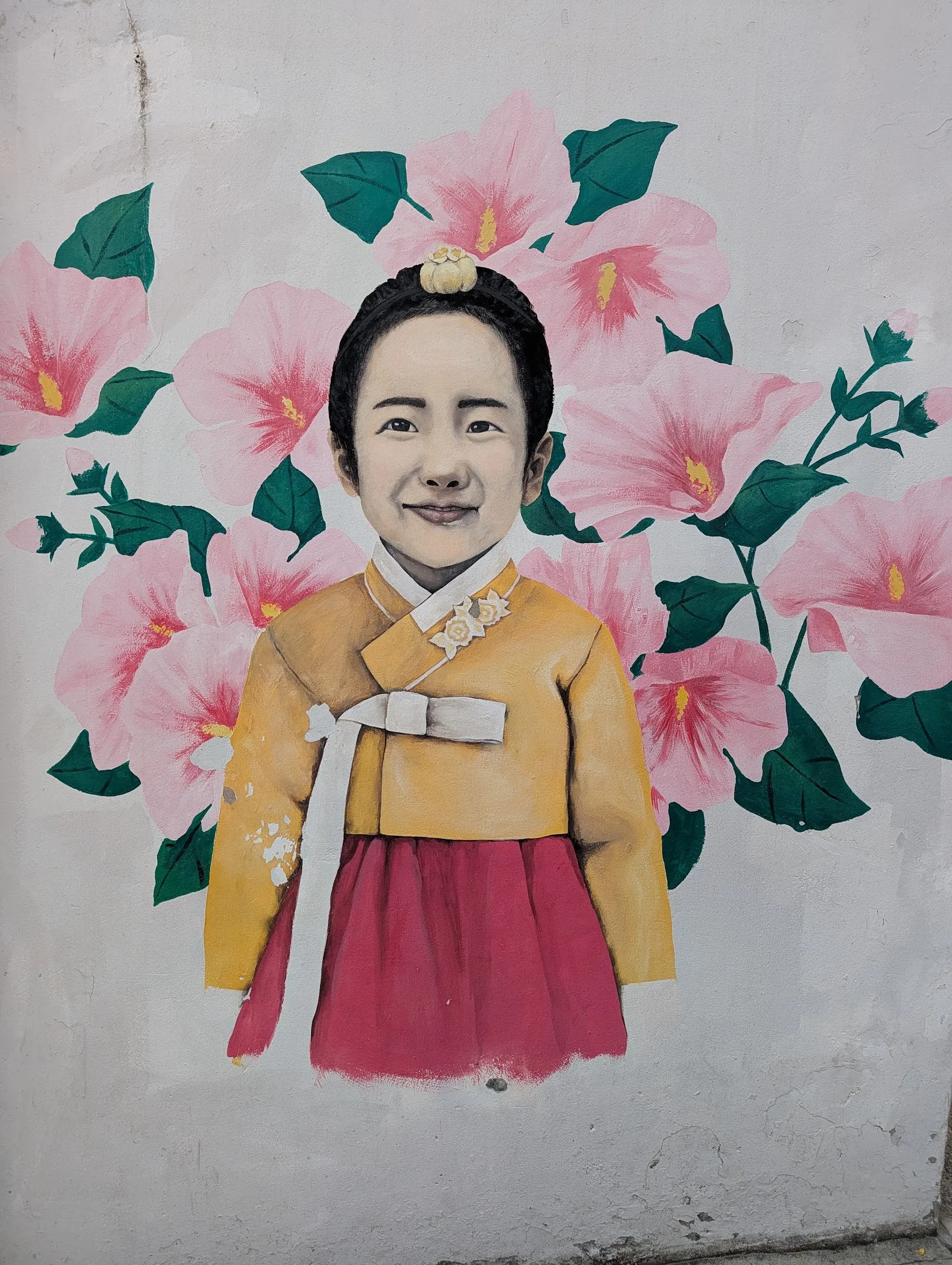 Mural de una mujer con hanbok rodeada de flores de hibisco