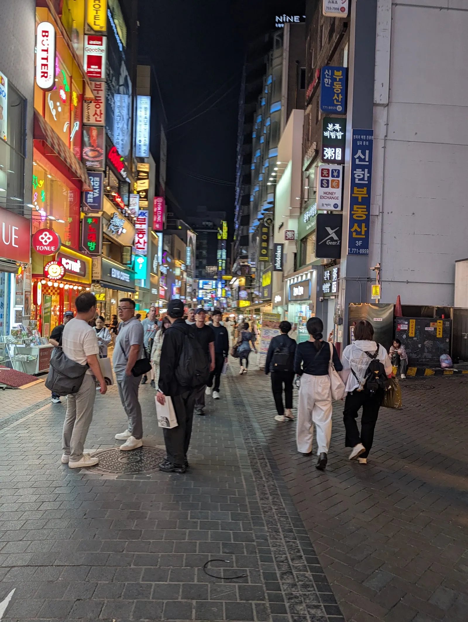 La calle de Myeongdong de noche, llena de carteles luminosos y gente
